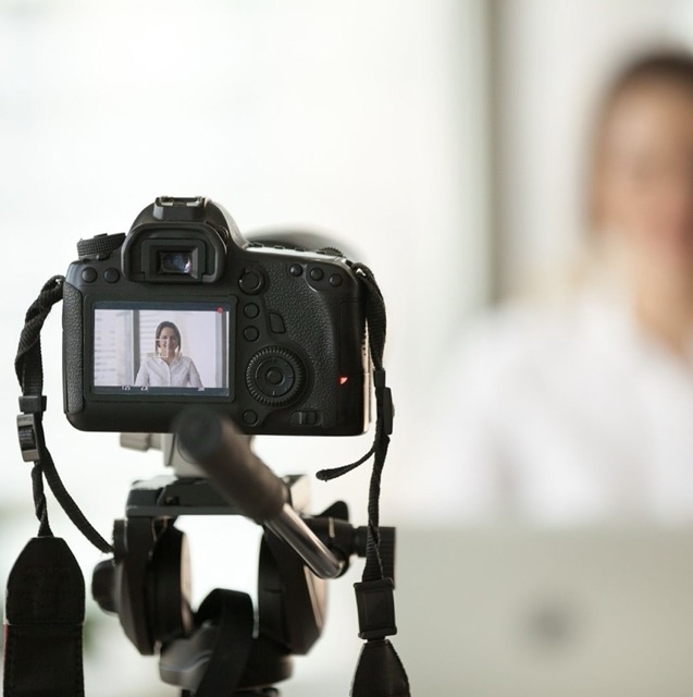 Appareil photo filmant une jeune femme lors d'un reportage